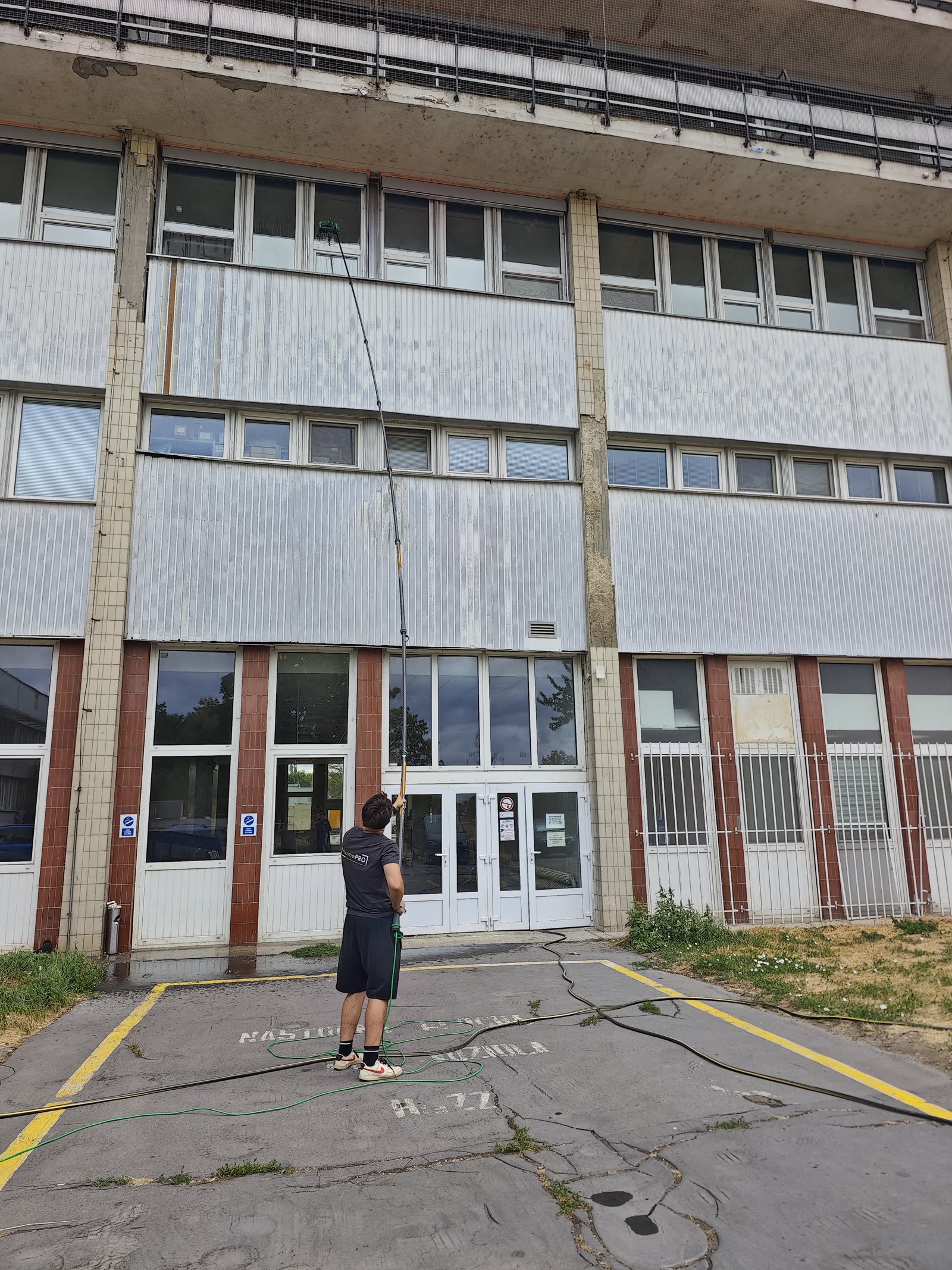 Umývanie okien administratívnej budovy teleskopickou tyčou UNGER zo zeme