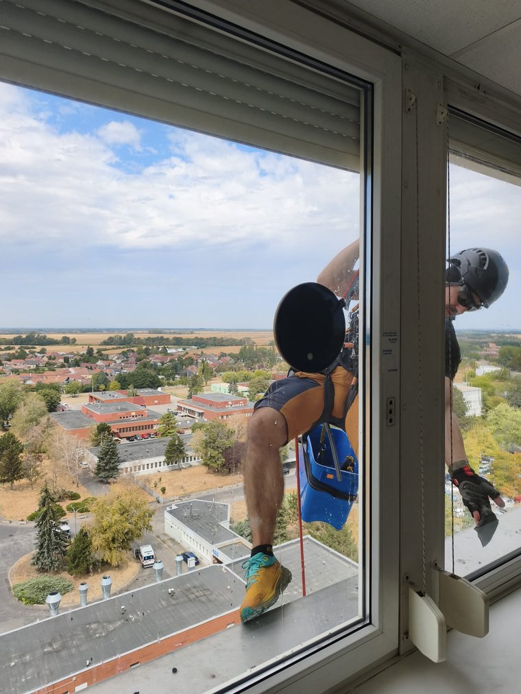 Umývanie okna vo výške lanovým prístupom, pohľad z budovy